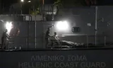 De Griekse kustwacht draagt de  lichamen van migranten van boord, die omkwamen bij de schipbreuk  voor de Griekse kust bij Pylos.    