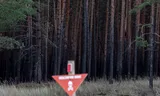 Een waarschuwingsbord voor geblakerde bomen in het bos bij Izjoem.