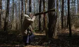 De 79-jarige Oleksandra Vasejko in het bos waar Polen begraven liggen die zijn omgekomen bij ‘het bloedbad van Wolynië’. 