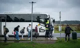 Vluchtelingen wachten op de pendelbus naar Emmen, vlakbij bij het aanmeldcentrum in Ter Apel. 