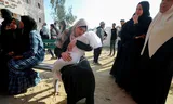 Een Palestijnse vrouw houdt het lichaam vast van een kind, dat is gedood door een Israëlisch bombardement in Noord-Gaza op 28 april. Foto Mahmoud Issa 