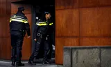 Politieagenten in operationeel uniform gaan een politiebureau  in Groningen binnen. 