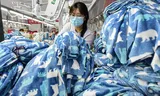 Een werknemer maakt pyjama’s in een Chinese kledingfabriek. De prijzen van Amerikaanse webwinkels voor producten uit China zijn fors toegenomen. 