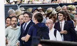 Voormalig Catalaans president Carles Puigdemont (links van het midden, met stropdas) betreedt het podium voordat hij zijn aanhangers toespreekt in Barcelona.