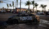 Een uitgebrande auto bij confrontaties tussen politie en demonstranten tegen aanhoudingen door immigratiedienst ICE, afgelopen zaterdag in voorstad Paramount. Foto Daniel Cole/Reuters 