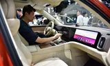 Een bezoeker probeert een auto van Huawei uit op de internationale autobeurs in Shenzhen. 