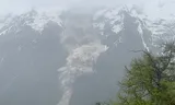 Een muur van modder en stenen glijdt van een berg af nadat de gletsjer gedeeltelijk is gesmolten en afgebrokkeld.