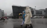Mensen lopen zondag met bloemen langs het zalencomplex Crocus City Hall in de Moskouse voorstad Krasnogorsk, om hun medeleven te betuigen met slachtoffers van de terreuraanslag van vrijdag. 