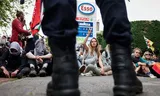 Demonstranten van Extinction Rebellion zijn door de politie op de grond gezet bij het Esso-tankstation bij het Malieveld.  Foto Jeffrey Groeneweg 