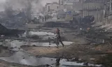 Palestijns meisje rent langs verwoeste gebouwen in Gaza-Stad.