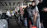 Vanwege de treinstoring wachten reizigers op een taxi of pendelbus. Foto Bram Petraeus