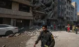 Een Iraanse politieagent loopt voorbij een woongebouw dat vrijdag is verwoest door de Israëlische aanvallen op Teheran. Foto Morteza Nikoubazl/NurPhoto via Getty Images 