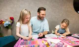 Daan Oomen aan het tekenen met dochters  Elodie (7) en Alysee (4). 