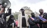 De broer van Aboubakar Cissé, die vorige week werd doodgestoken in een moskee in het zuiden van Frankrijk, afgelopen zondag bij een demonstratie in Parijs. Foto Teresa Suarez / EPA  