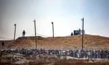 Leden van een particulier Amerikaans beveiligingsbedrijf, zien toe hoe Palestijnen zich verzamelen om voedsel te ontvangen, 8 juni.
