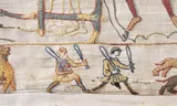 De kwestie is of de rennende man rechts nu wel of geen penis onder zijn tuniek uit heeft bungelen. Foto: Bayeux Museum