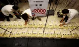 Door de overheid opgeslagen rijst wordt klaargelegd in een Japanse supermarkt in Tokio. Foto’s Issei Kato/Reuters; Yuichi YAMAZAKI/AFP    