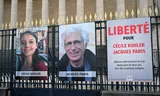 Foto’s van de twee docenten  hangen  bij de Nationale Assemblee in Parijs. Foto Betrand Guay/AFP 