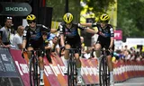 Demi Vollering wordt  bij de finish van de derde etappe vergezeld door haar teamgenoten Amber Kraak (links) en Juliette Labous. Foto  Julien de Rosa/AFP   