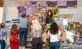 Vrijwilligers werken aan een wandtapijt in de Oude Kerk in Delft. Foto Myriam Sheldon Robert 