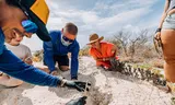 Daan Zeegers (links) bij een nest van een zeeschildpad, samen met andere medewerkers van Sea Turtle Conservation Bonaire. 