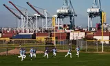 In de schaduw van de haven van Los Angeles lopen honkballers zich warm. 