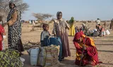 Soedanese vluchtelingen  zetten een geïmproviseerde tent op in het kamp Iridimi in Tsjaad. Foto Wang Guansen/Xinhua/ANP 