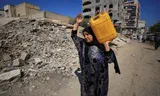 Een Palestijnse vrouw met een jerrycan water.