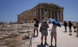Toeristen op de Acropolis in Athene, tijdens de hittegolf van deze week. 
