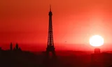 Zonsopkomst bij de Eiffeltoren in Parijs, terwijl in de Franse hoofdstad code rood geldt vanwege de hoge temperaturen afgelopen juni.   